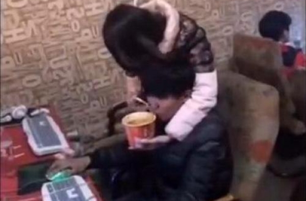 小伙网吧玩LOL团战如大爷 媳妇在旁点烟喂饭还按摩